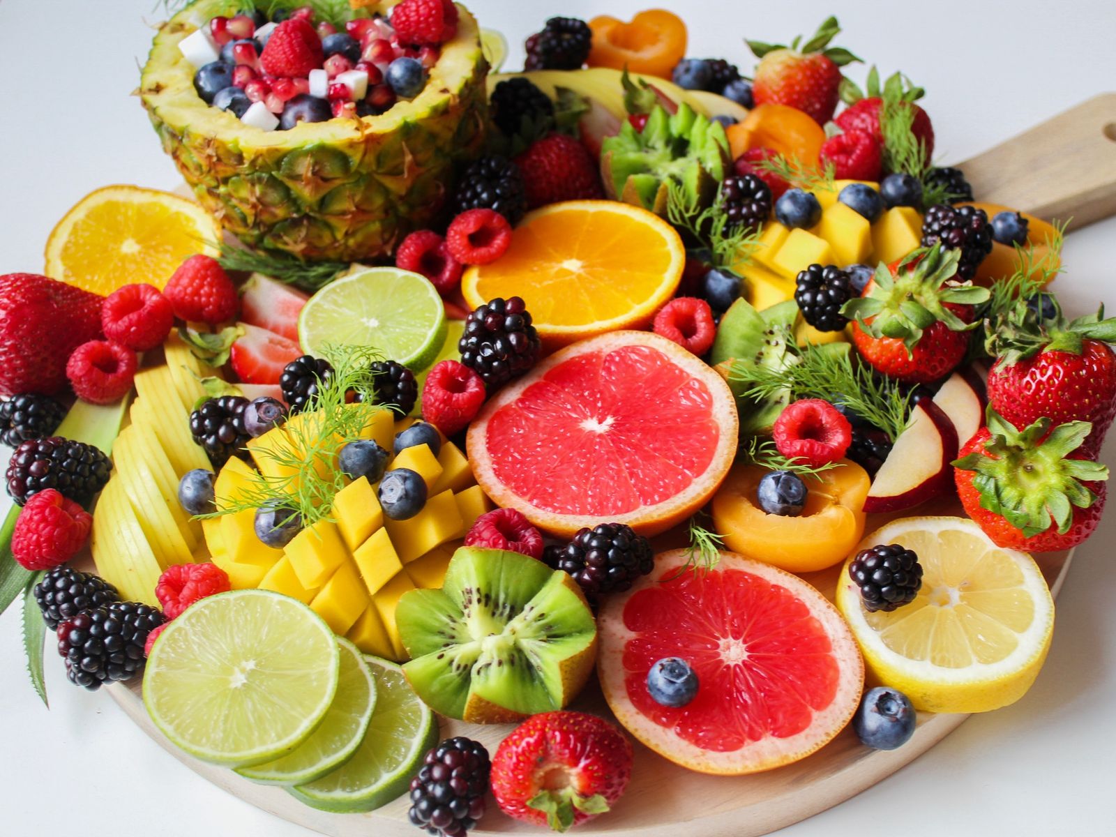 Assorted fresh fruits including strawberries, oranges, grapes and apples arranged together